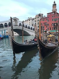 Canal amidst buildings in city against sky