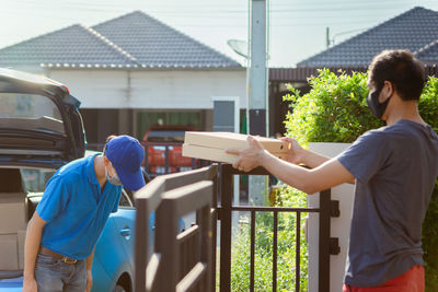 Rear view of people standing outside house