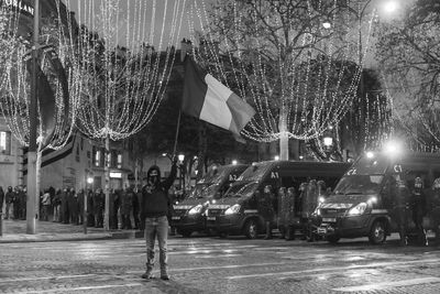 People on illuminated street at night