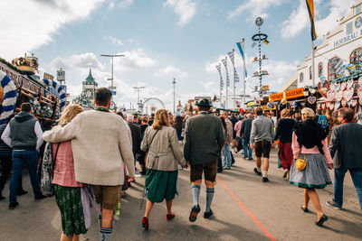 Rear view of people walking on street in amusement park