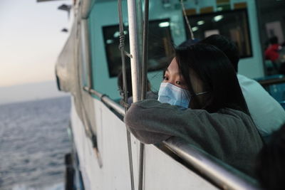 Girl wearing mask standing on boat