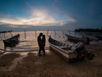 Couple romancing at beach against sky