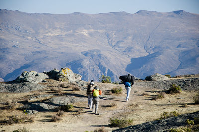 Men standing on rocks against mountains