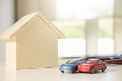 Close-up of toy cars and model house on table