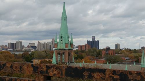 View of cityscape against cloudy sky