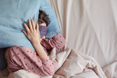 Low section of woman lying on bed at home