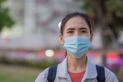 Portrait of woman wearing mask standing outdoors