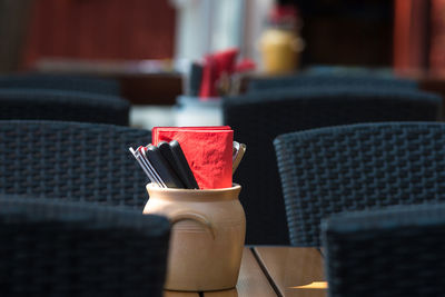 Napkins and spoons in container on table at restaurant