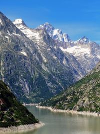 Scenic view of lake and snowcapped mountains against sky