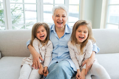 Portrait of happy family sitting on sofa at home