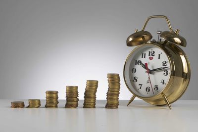 Close-up of clock on table against white background