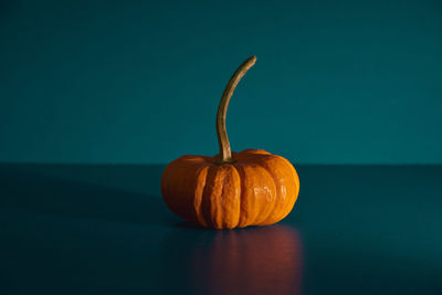 Close-up of pumpkin on table against wall