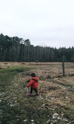 Boy playing on grass against sky