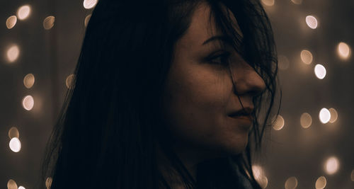 Close-up portrait of woman looking away at night