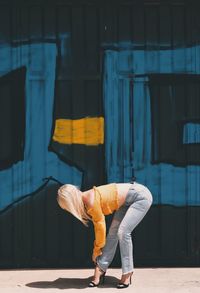 Blond woman tying her high heels front of a tag