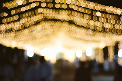 Low angle view of illuminated defocused lights at night