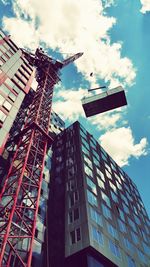 Low angle view of modern building against cloudy sky