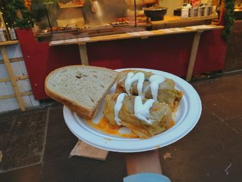 Close-up of hand holding bread in plate