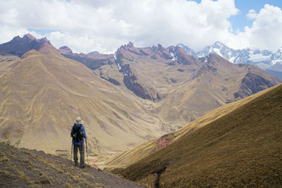 Rear view of woman standing on mountain against sky