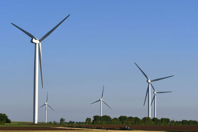 Low angle view of windmill on field against sky