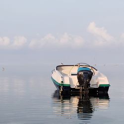 Fishing boat moored on sea against sky