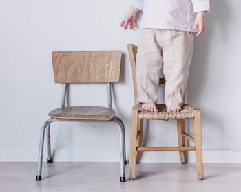 Low section of child standing on chair