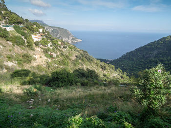 Scenic view of sea and mountains against sky