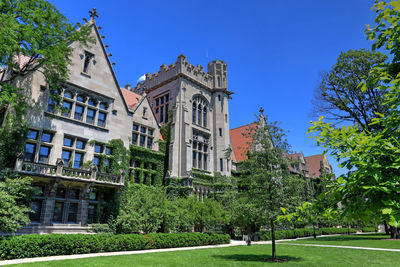 Low angle view of trees and building against sky