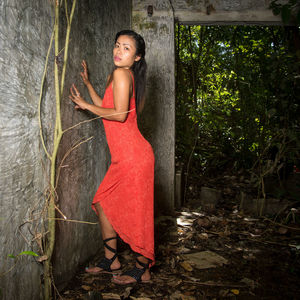 Portrait of woman standing in abandoned building at forest 