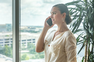 Woman looking away while talking on smart phone