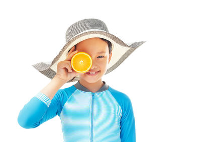 Portrait of boy holding hat against white background