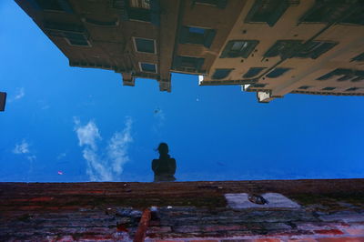 Reflection of woman and buildings in canal