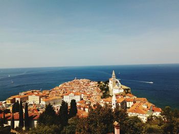 High angle view of buildings by sea against sky