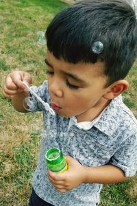 Midsection of boy drinking water on field