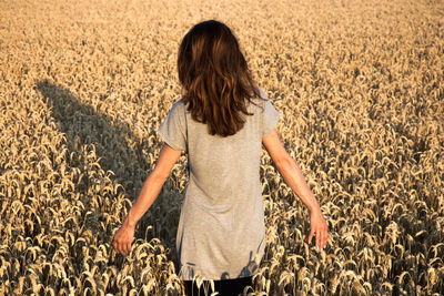 Rear view of woman standing in farm