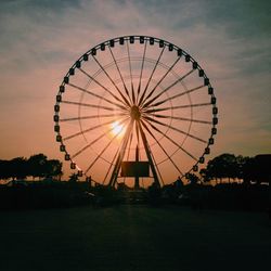 Ferris wheel against sky at sunset