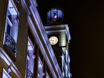 Low angle view of illuminated clock tower at night