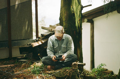 Full length of man sitting outdoors