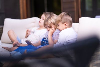 Boy and girls sitting on sofa at home