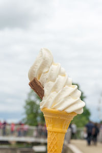 Close-up of ice cream cone against sky