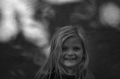 Portrait of smiling girl against wall