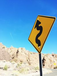 Road sign against clear blue sky