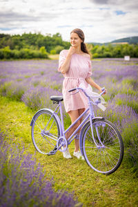 Full length of woman with bicycle on field