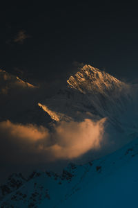 Scenic view of snowcapped mountains against sky during sunset