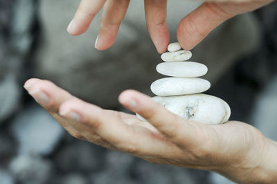 Cropped hand stacking pebbles