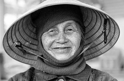 Portrait of senior woman wearing asian style conical hat