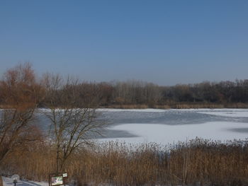 Scenic view of lake against clear sky during winter