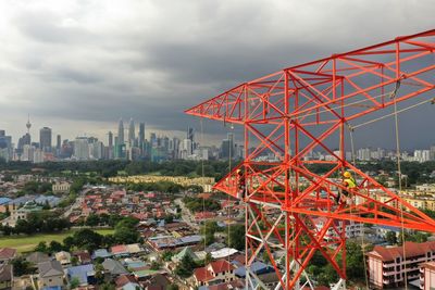 Ferris wheel by buildings against sky in city