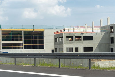 Buildings by road against sky in city