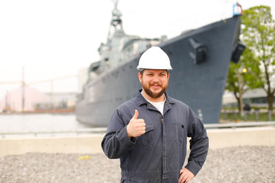 Portrait of sailor standing against ship